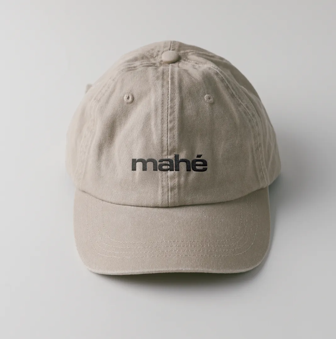 Beige mahé embroidered cap on a light grey surface